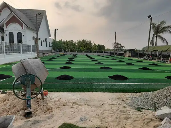 Công đoạn ra hạt cao su cho sân bóng đá